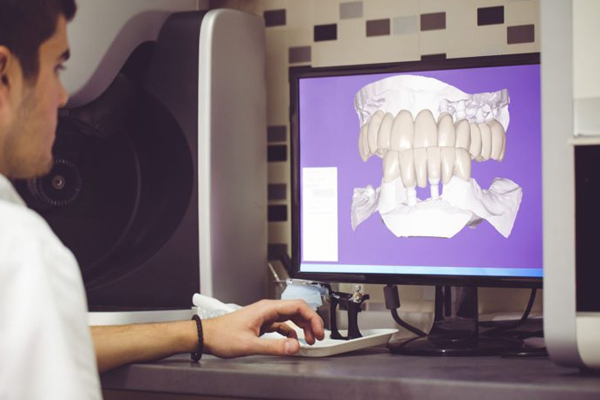Dentist viewing dental X-ray on computer monitor in clinical office setting.