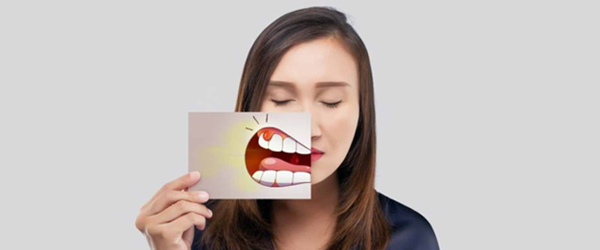 Woman holding card with bright smile photo, demonstrating dental care and whitening results.
