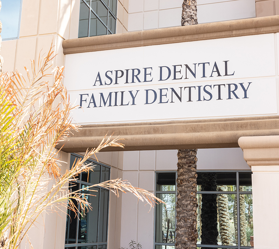 Aspire Dental Family Dentistry storefront with signage, palm tree, and glass entrance doors.